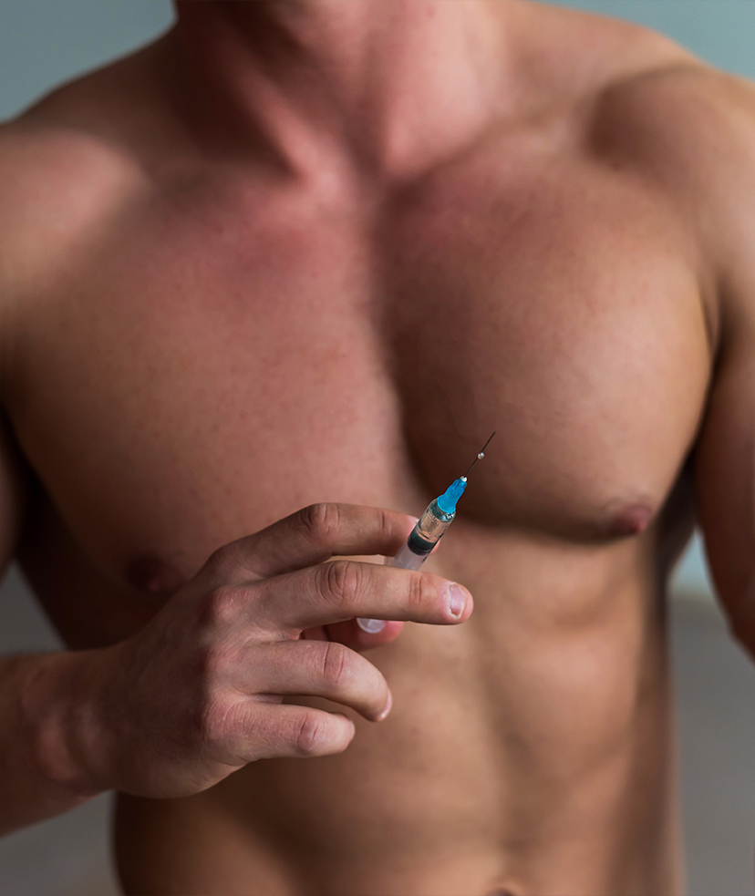 Photo of a muscular man holding a syringe with anabolic steroids