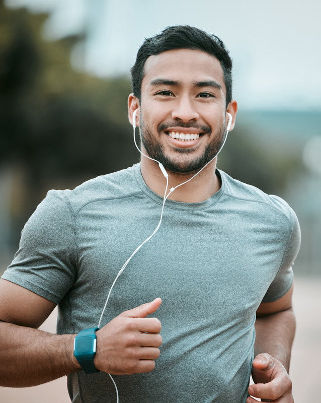 Photo of a man running and listening to headphones