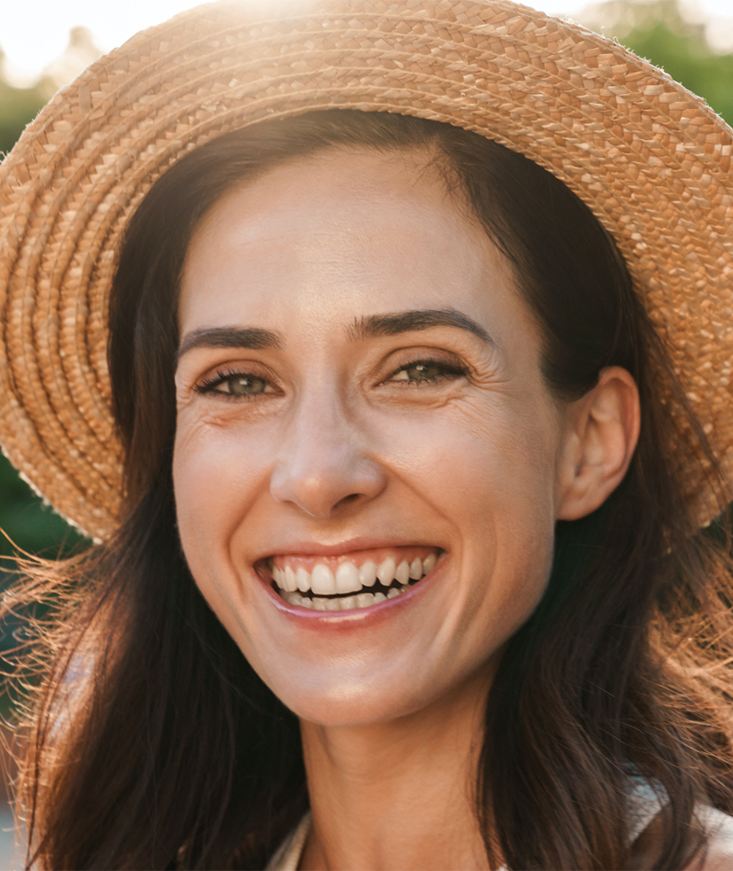 Photo of a smiling woman wearing a summer hat