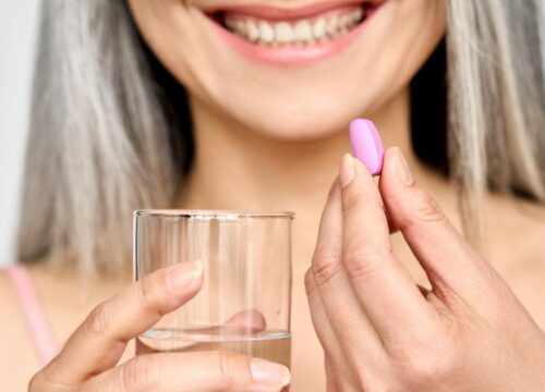 Photo of a woman taking a collagen supplement
