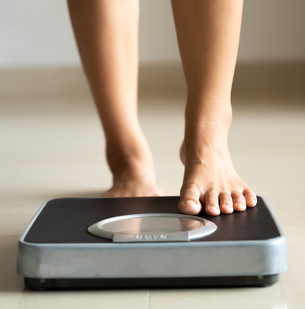 Photo of a woman stepping onto a scale