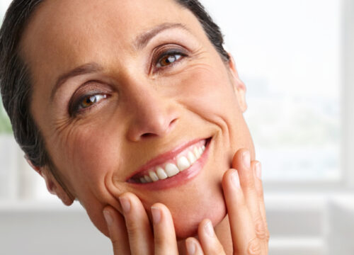 Photo of a middle-age woman with wrinkles touching her face